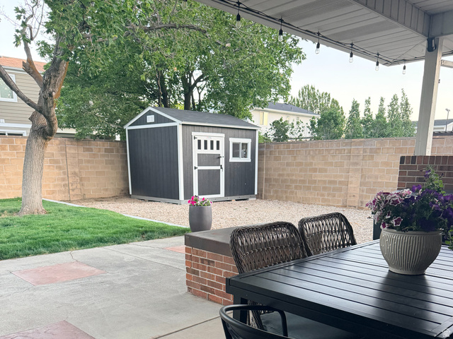 11530 Jordan Point Drive Sandy, UT 84092 - Photo 33 of 34 Covered patio area featuring string lighting, brick half-wall, and concrete flooring