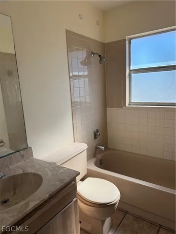 a bathroom with a granite countertop toilet sink and mirror