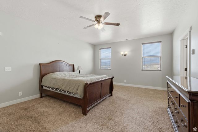 2567 West Rim Rock Drive Stockton, UT 84071 - Photo 18 of 64 Carpeted room featuring light gray walls, two windows with horizontal blinds, a ceiling fan with integrated lighting, and a wall-mounted light fixture