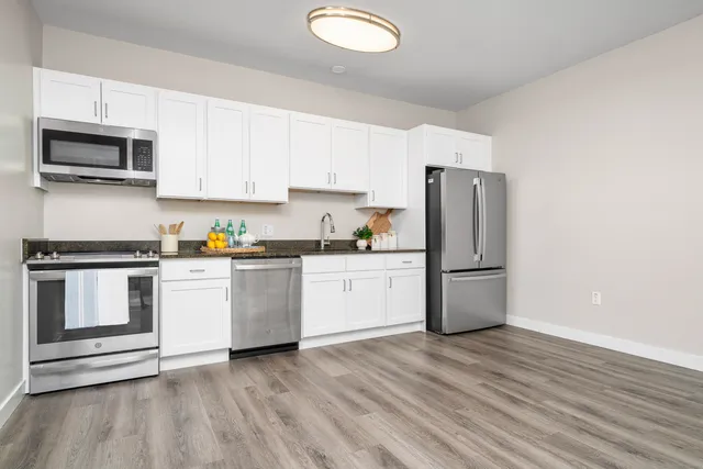 a kitchen with a refrigerator stove and white cabinets