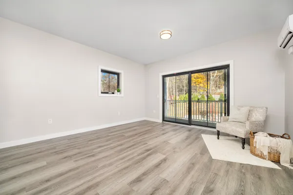 a view of a bedroom with wooden floor and a window