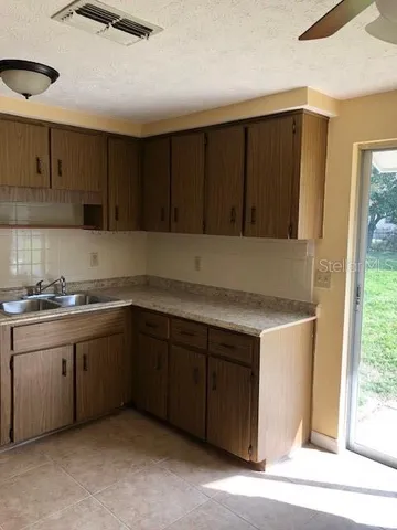 a kitchen with a sink cabinets and a window