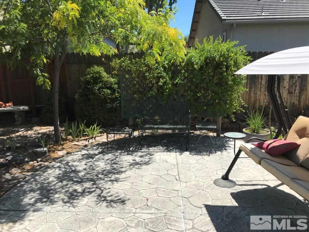 4610 Goodwin Road Sparks, NV 89436 - Photo 27 of 31 a view of backyard with wooden fence and a table and chairs under an umbrella