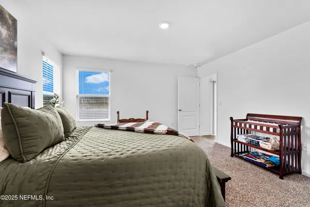 a bedroom with a bed table and a window