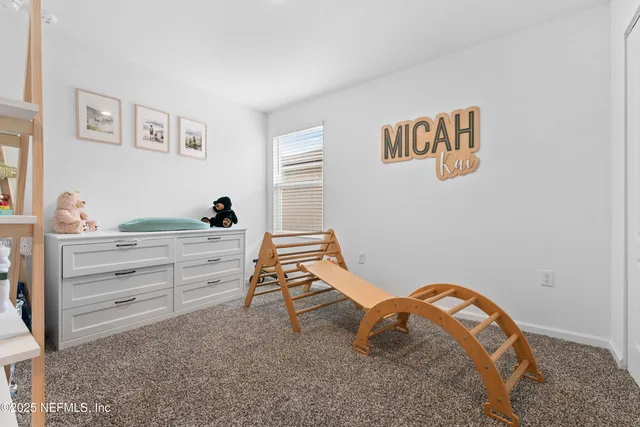 a bedroom with a bed and a lamp on dresser