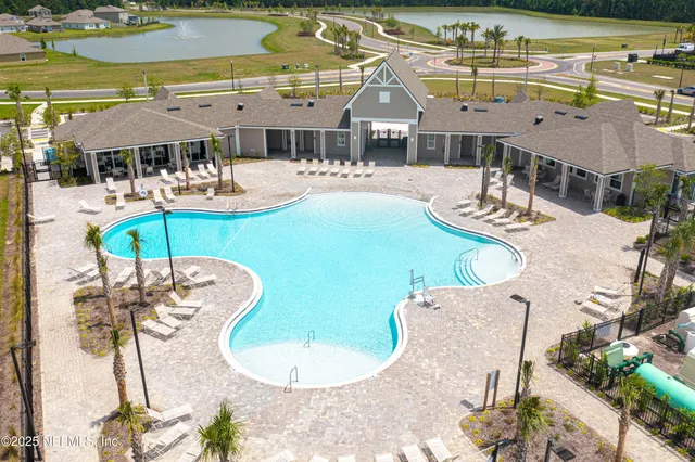 an aerial view of a swimming pool with outdoor seating