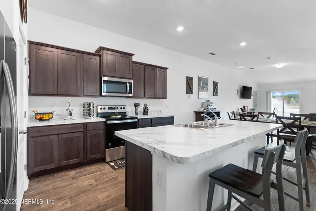 a kitchen with a sink a stove and chairs