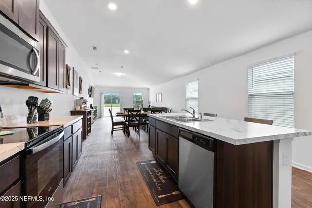 a kitchen with lots of counter top space a sink appliances and cabinets