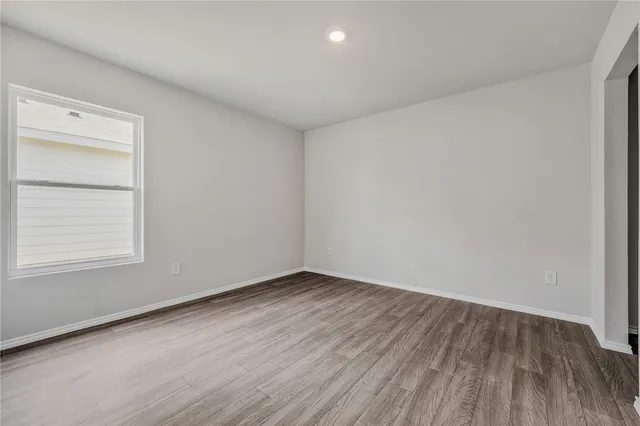 an empty room with wooden floor and window