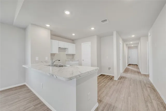 a large white kitchen with a sink and dish washer