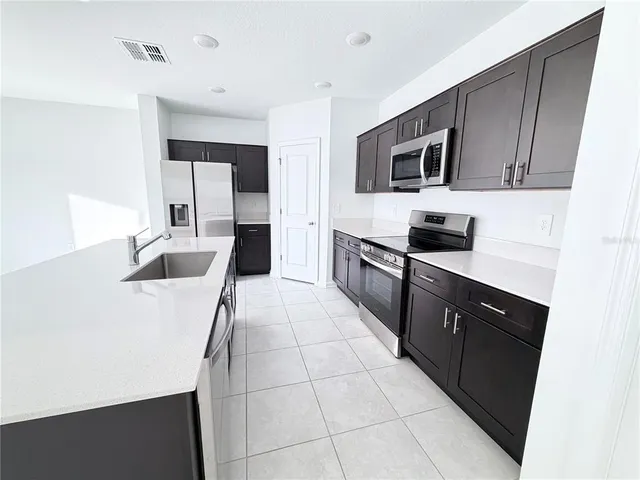 a kitchen with stainless steel appliances a stove sink microwave and refrigerator