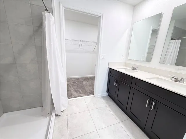 a bathroom with a double vanity sink a mirror and a bathtub