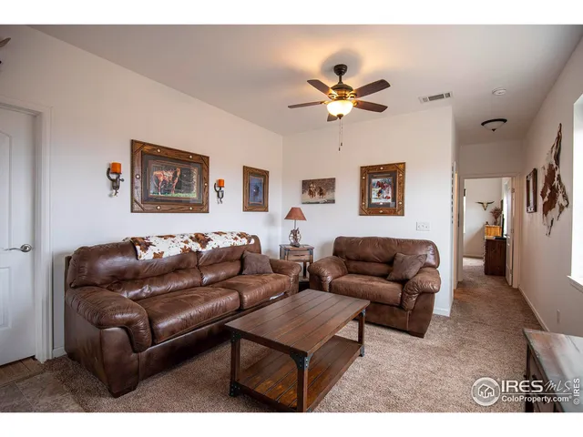 a living room with furniture and a ceiling fan