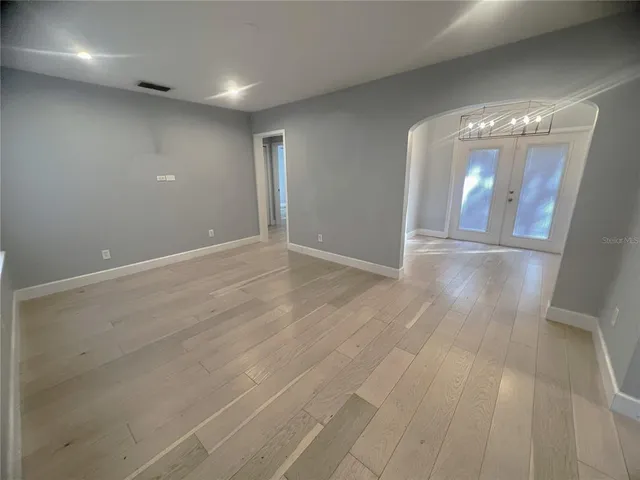 an empty room with wooden floor and stairs