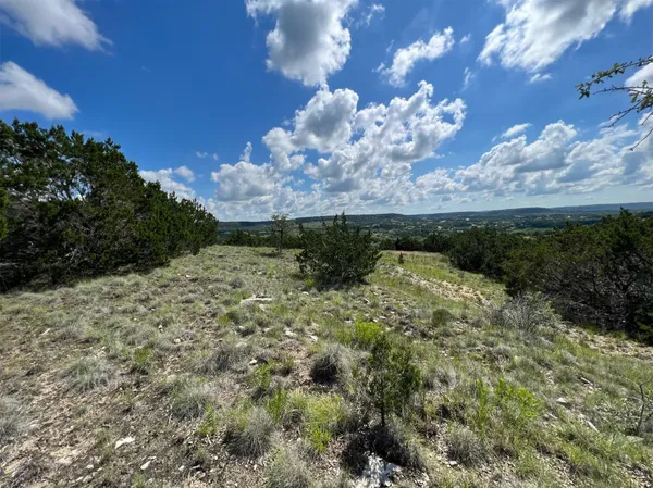 a view of a big yard with table and chairs under an umbrella
