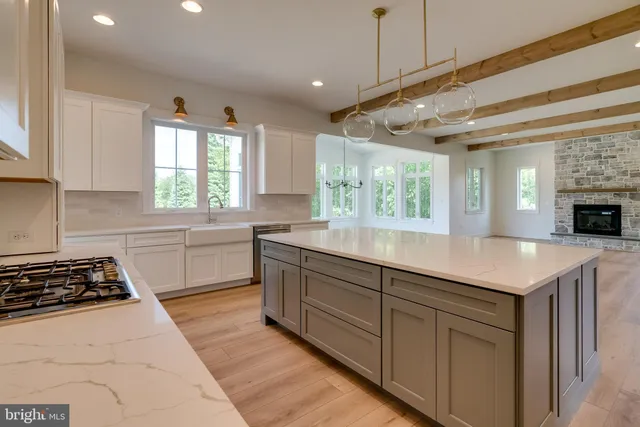 a kitchen with a stove a sink a center island and a window