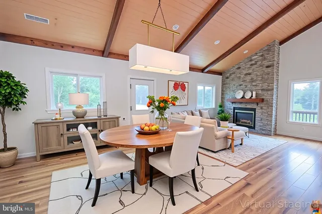 a kitchen with stainless steel appliances granite countertop a stove top oven a sink dishwasher and white cabinets with wooden floor