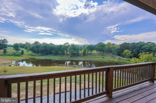 an aerial view of green landscape with trees houses and lake view