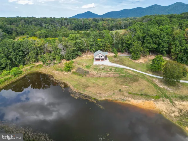 a house that has a big wooden fence and a yard