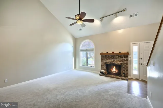 a view of empty room with fireplace and fan