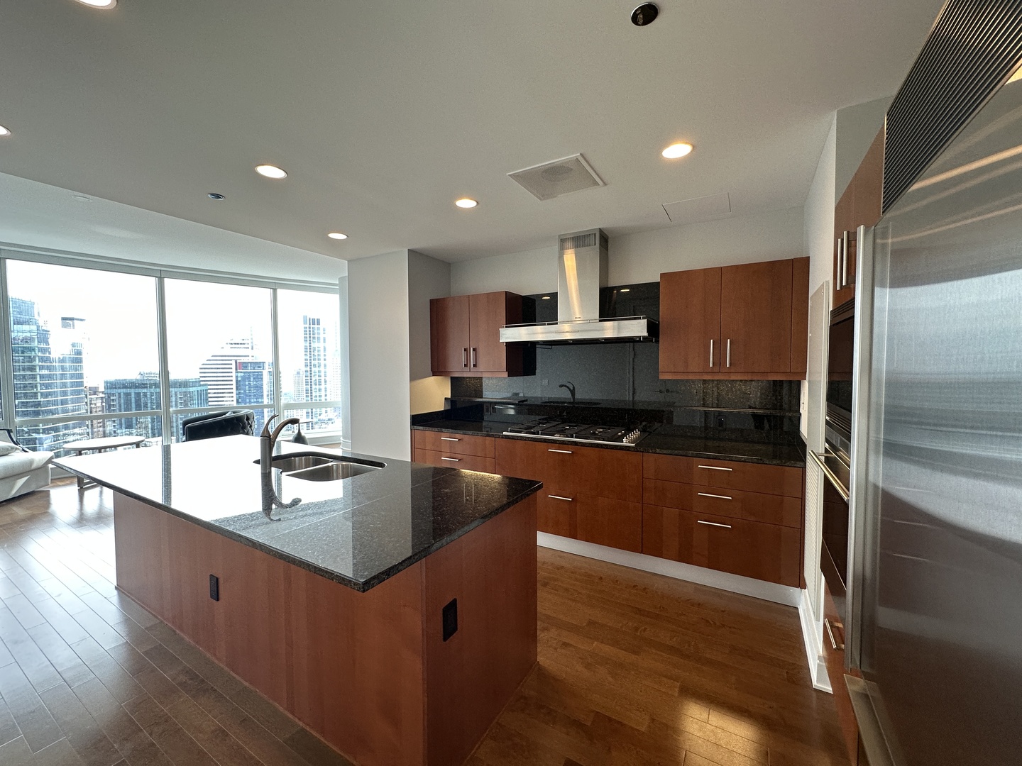 401 North Wabash Avenue, Unit 32H Chicago, IL 60611 - Photo 4 of 16 a large kitchen with kitchen island a large window a sink and stainless steel appliances