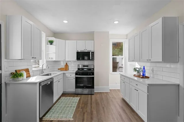 a kitchen with stainless steel appliances granite countertop a sink stove and refrigerator