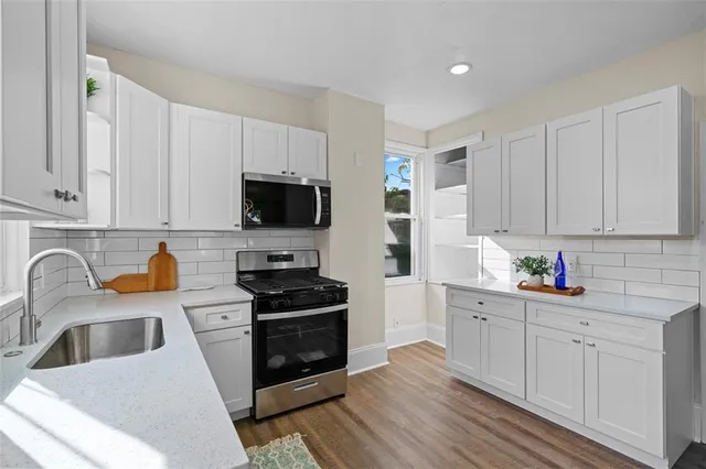 a kitchen with stainless steel appliances a stove a sink a microwave and cabinets