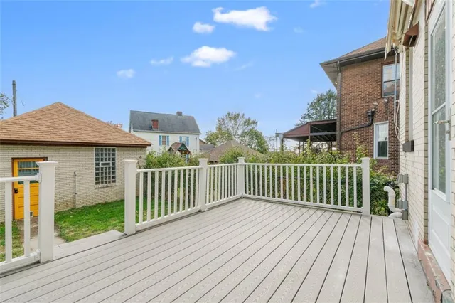 a view of a house with a small yard and wooden floor and fence
