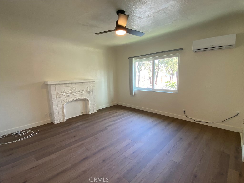 5103 Lindsey Avenue, Unit A Pico Rivera, CA 90660 - Photo 5 of 14 wooden floor in an empty room with a fireplace
