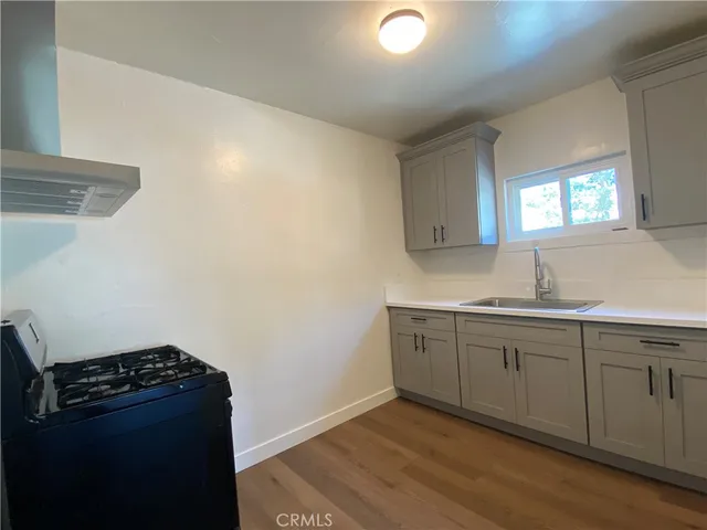 a kitchen with granite countertop cabinets and stove top oven