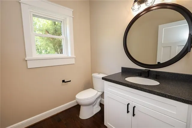 a bathroom with a granite countertop toilet and a sink
