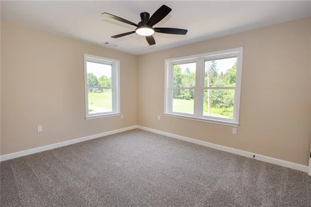 a view of a livingroom with a ceiling fan and window
