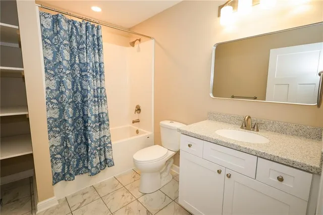 a bathroom with a granite countertop sink toilet mirror and shower
