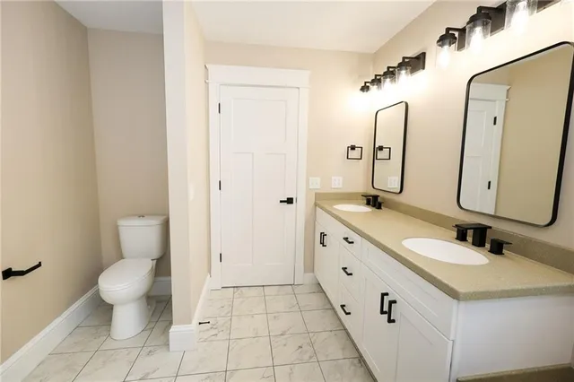 a bathroom with a double vanity sink mirror and toilet