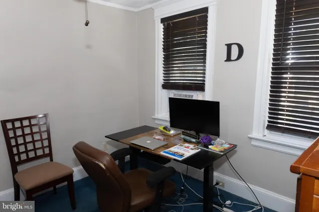 a view of a workspace with furniture and a window