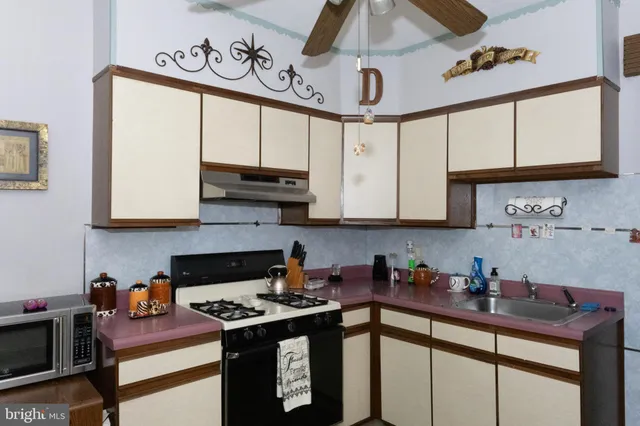 a kitchen with stainless steel appliances granite countertop a sink stove and cabinets