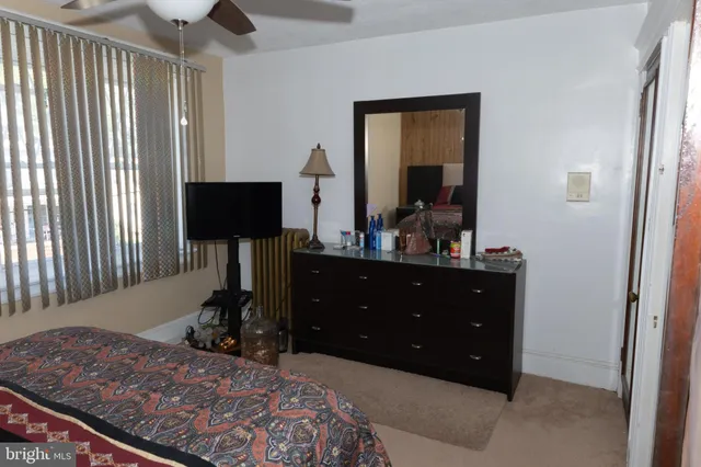 a bedroom with a bed and a mirror on dresser