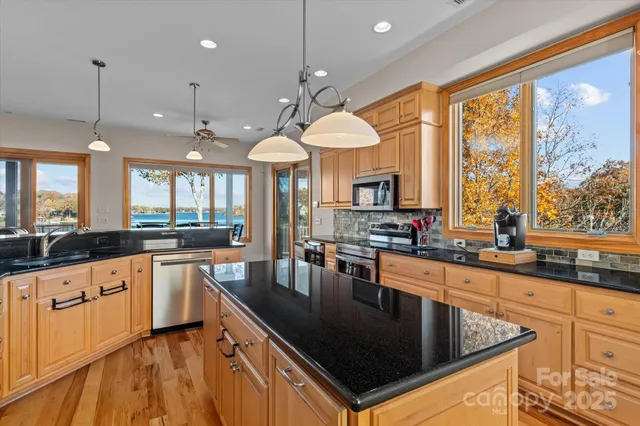 a kitchen with granite countertop a sink and white cabinets