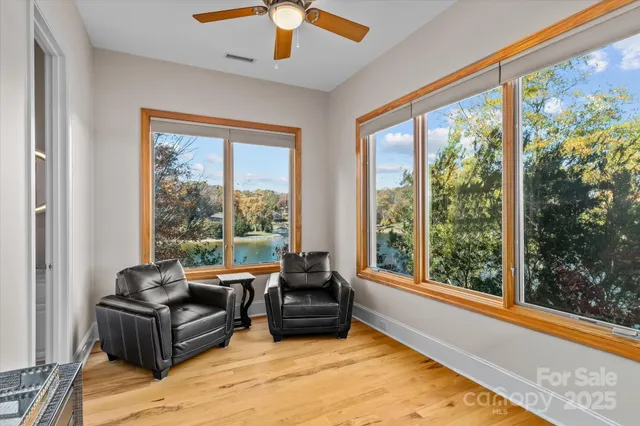 a view of a bedroom with wooden floor and windows