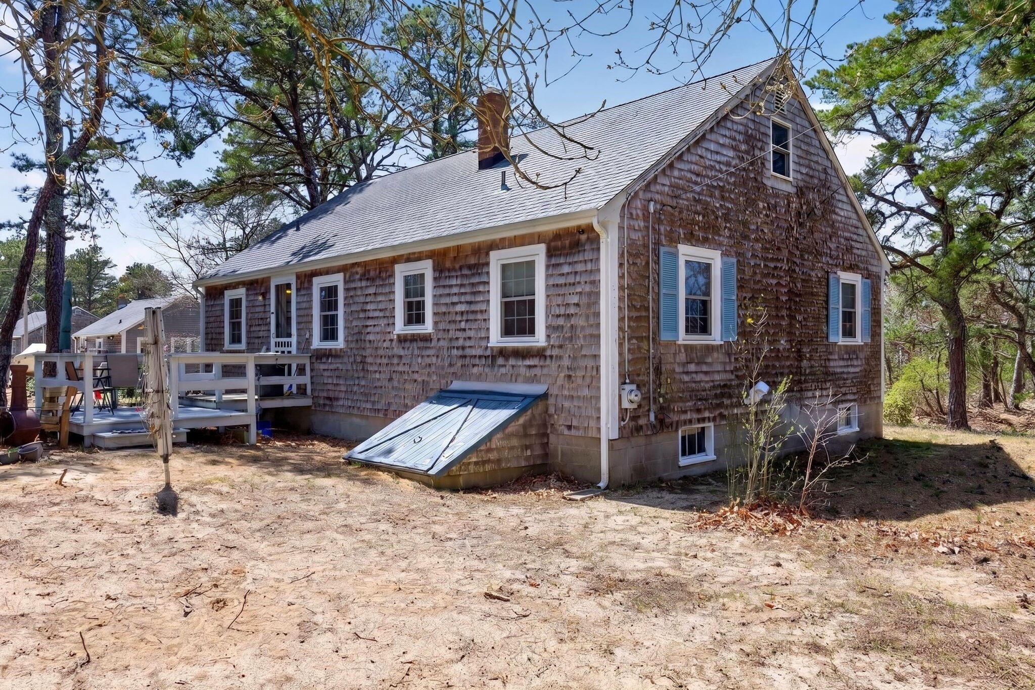 20 Fresh Brook Lane, Unit A Wellfleet, MA 02667 - Photo 31 of 35 a view of a house with a yard chairs and wooden fence