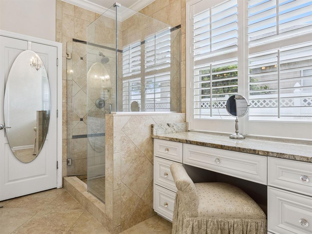13403 Riggs Way Windermere, FL 34786 - Photo 24 of 47 a bathroom with a granite countertop sink a mirror and a shower