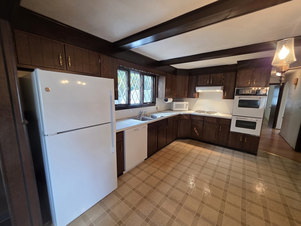 80 Ann Street Chicopee, MA 01020 - Photo 11 of 20 a kitchen with granite countertop a refrigerator a sink a stove a washer dryer and a refrigerator