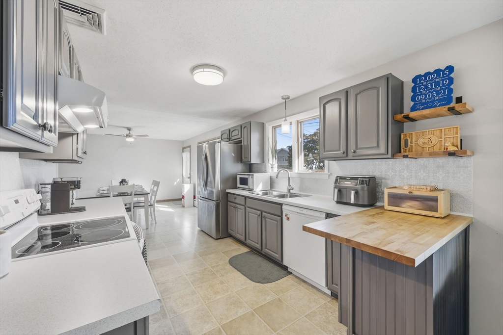 20 Connolly Street Springfield, MA 01151 - Photo 14 of 41 a kitchen with a sink stove and wooden cabinets