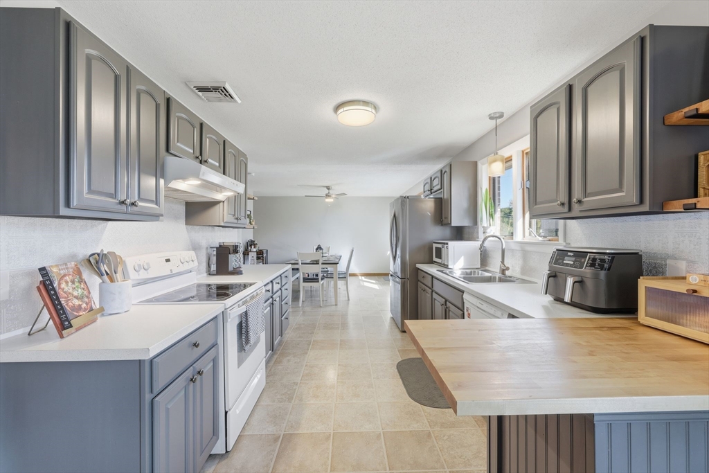 20 Connolly Street Springfield, MA 01151 - Photo 16 of 41 a kitchen with stainless steel appliances granite countertop a sink a stove and a wooden cabinets