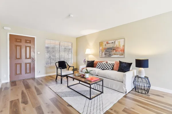 a living room with furniture and a wooden floor