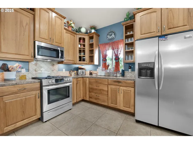 a kitchen with kitchen island a counter top space cabinets and stainless steel appliances