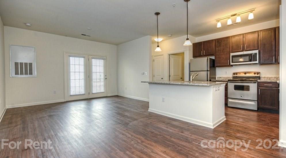 4310 Park Road, Unit 206 Charlotte, NC 28209 - Photo 4 of 13 a kitchen with stainless steel appliances granite countertop a sink a stove a refrigerator and a microwave