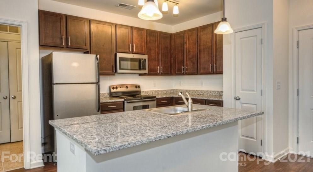 4310 Park Road, Unit 206 Charlotte, NC 28209 - Photo 6 of 13 a kitchen with stainless steel appliances granite countertop a sink stove and refrigerator