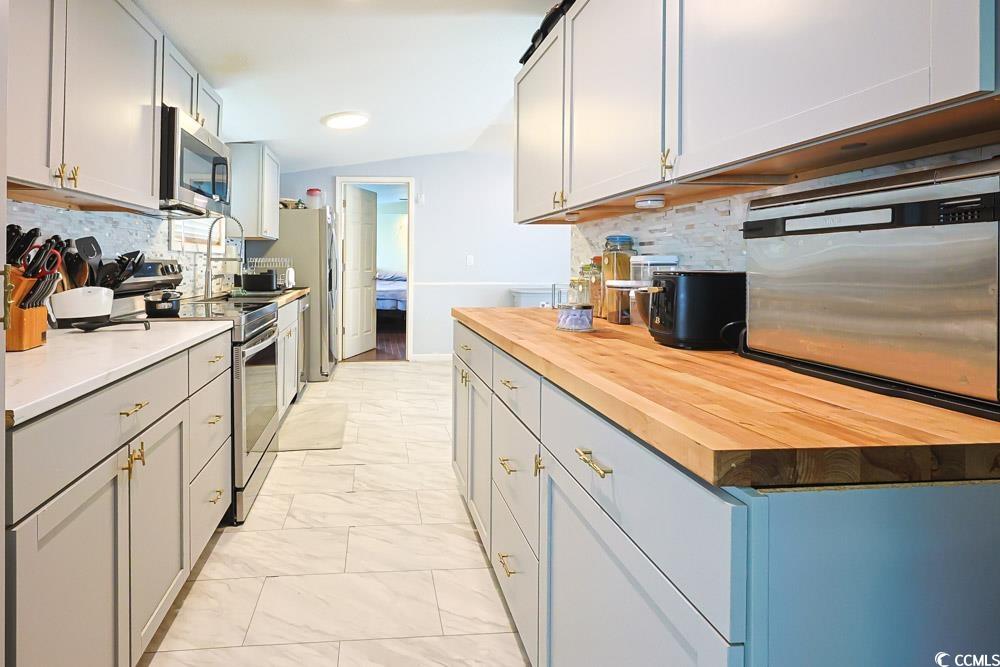 1911 Abba Court Conway, SC 29526 - Photo 7 of 25 Kitchen with wooden counters, appliances with stainless steel finishes, decorative backsplash, gray cabinetry, and light marble finish floors