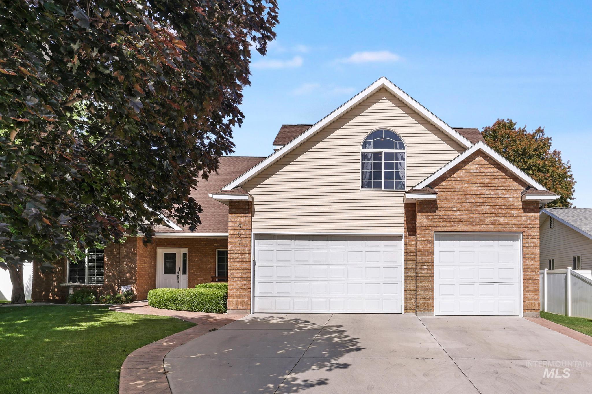 467 Wildrose Loop Twin Falls, ID 83301 - Photo 1 of 46 Traditional-style exterior with brick and siding facade, featuring a prominent arched window and a two-car garage